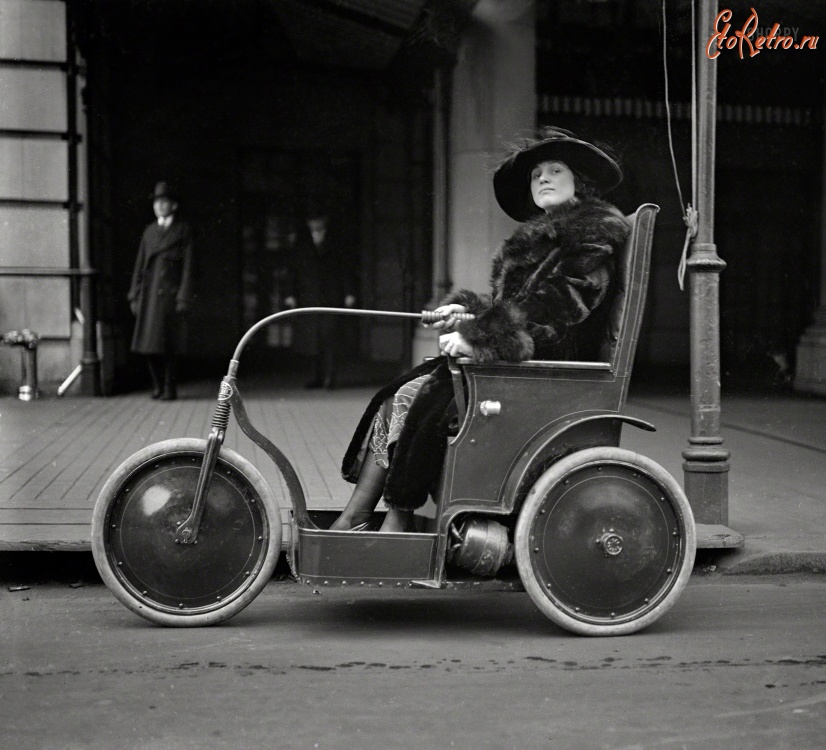 Ретро автомобили - Женщина в трехколесном автомобиле.