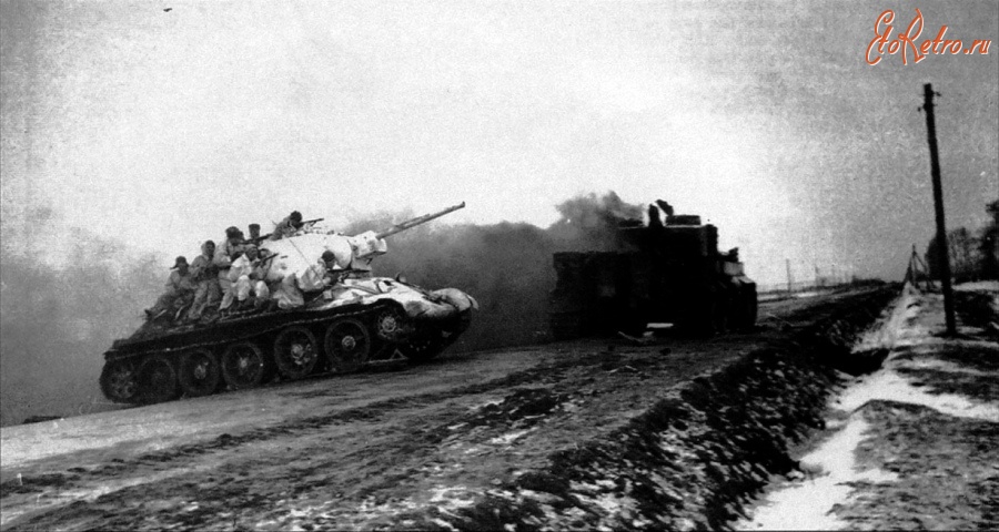 Житомир - Cоветский танк Т-34  с десантом пересекает магистраль Житомир-Бердичев. Горящий танк Pz.Kpfw. VI «Тигр».