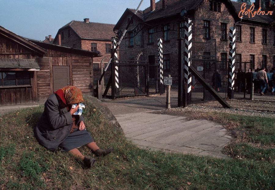 Польша - Жінка плаче поруч із воротами музею Освенцим. Bruno Barbey.