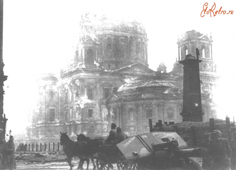 Берлин - Советская 122-мм гаубица М-30 на конной тяге в центре Берлина. На щите орудия надпись: «Отомстим за злодеяния». На заднем плане — Берлинский кафедральный собор.