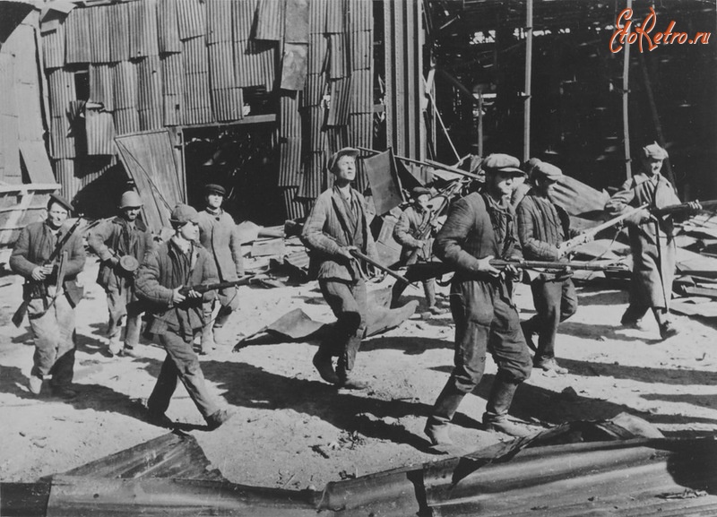 Волгоград - Ополченцы Сталинградского тракторного завода идут мимо полуразрушенного цеха.