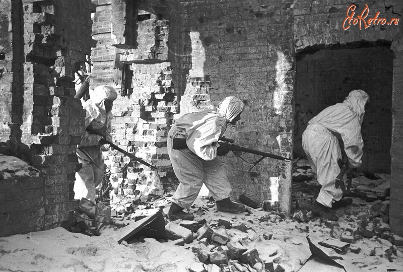 Волгоград - Советские снайперы выходят на огневую позицию в разрушенном доме в Сталинграде.