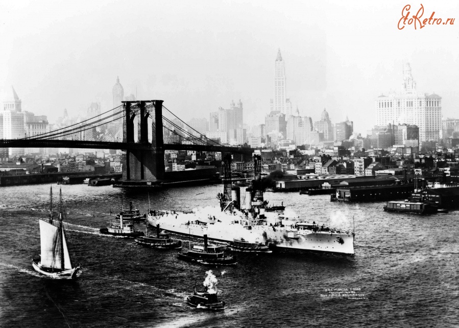 Нью-Йорк - Surrounded by helping tug boats, the Florida (BB-30) makes her way past the Brooklyn Bridge США,  Нью-Йорк (штат),  Нью-Йорк,  Манхеттен