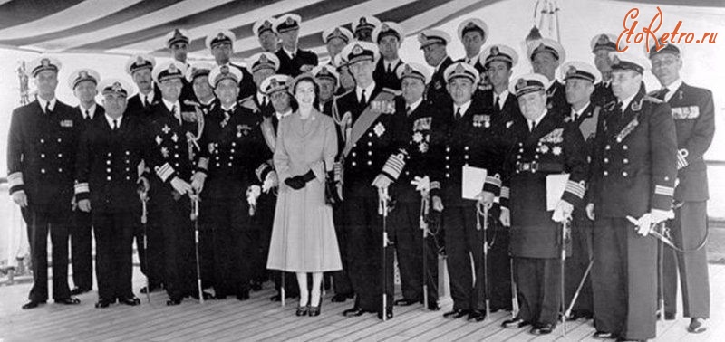 Англия - Королева Елизавета II стоит вместе с английскими офицерами ( у них пуговицы 8 штук. У советских 6 пуговиц). Слева и справа советские морские офицеры с крейсера «Свердлов»