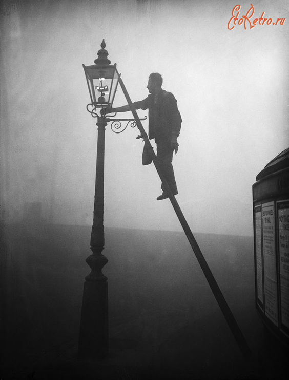 Лондон - Лондон.   Чоловік  запалює вуличний ліхтар.