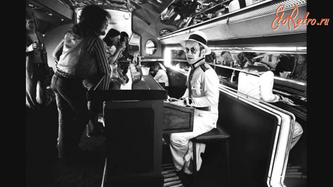 Ретро знаменитости - Элтон Джон в пиано-баре на борту своего частного самолета, 1976.