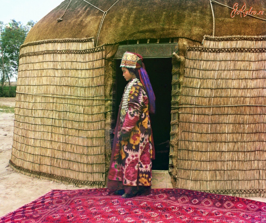 Туркменистан - Байрам-Али. Младшая жена текинца в парадном костюме у юрты, 1911