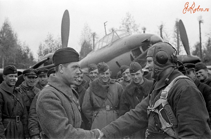 Ленинградская область - Командир авиачасти Королев (слева) поздравляет капитана Савкина с отличным выполнением боевого задания