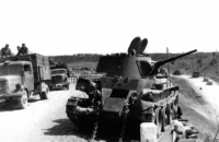 Войны (боевые действия) - Поврежденный советский танк БТ-7 на обочине дороги, по которой движется немецкая автоколонна.