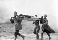 Войны (боевые действия) - Санитары выносят на носилках раненого с поля боя