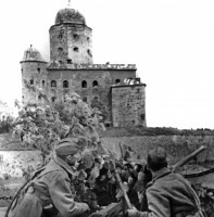 Выборг - Советские солдаты в Выборге на фоне выборгского замка с замаскированной 45-мм противотанковой пушкой.