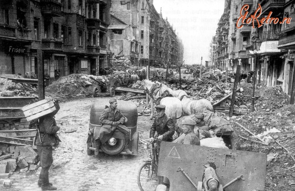 Берлин - Советские солдаты в Берлине по окончанию боев. На переднем плане и позади, за автомобилем — орудия ЗиС-3 образца 1943 года.