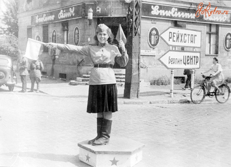 Берлин - Девушка регулирует движение советских войск на перекрестке улиц г.Берлина