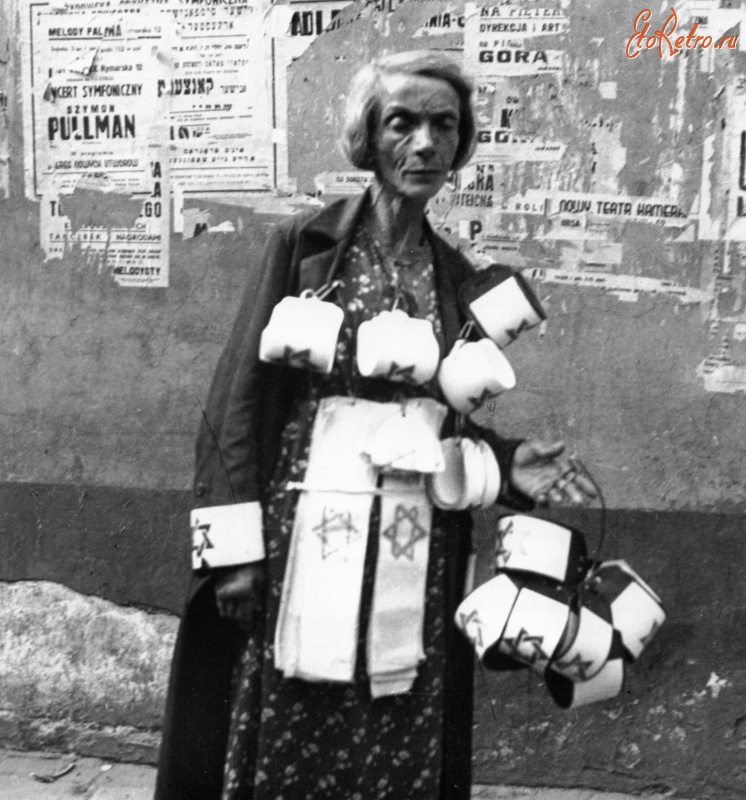 Варшава - Пожилая еврейка продает нарукавные повязки со звездой Давида на улице Варшавского гетто