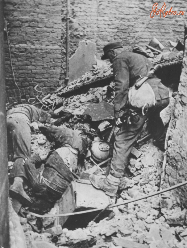 Варшава - Унтер-офицер СС осматривает тела двух варшавских повстанцев, убитых в Старом городе.