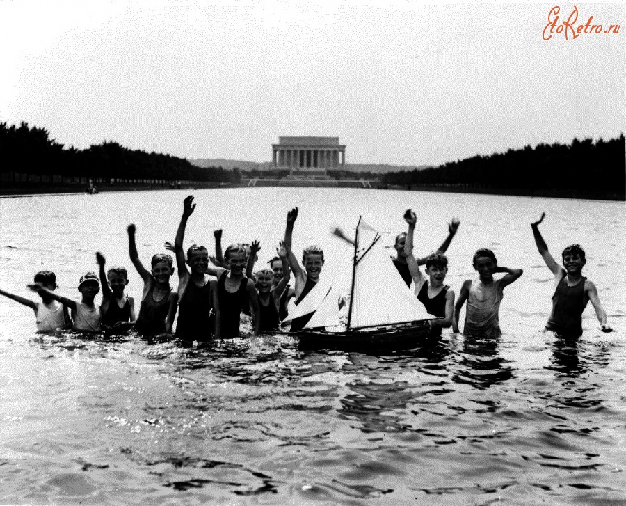 Вашингтон - Group of boys waving at the photographer while playing in the reflecting pool in front of the Lincoln Memorial with a toy sailboat США , Вашингтон (округ Колумбия)