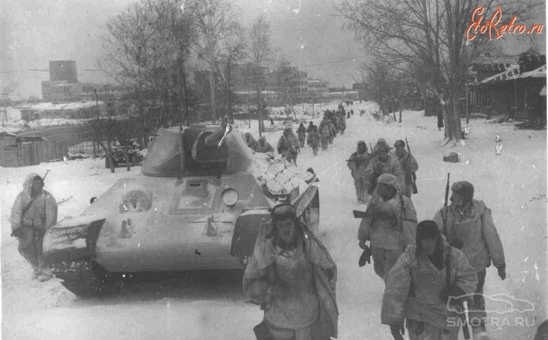 Московская область - Советские войска на марше. Контрнаступление советских войск под Москвой. На танк нанесен зимний камуфляж, все бойцы в маскхалатах.