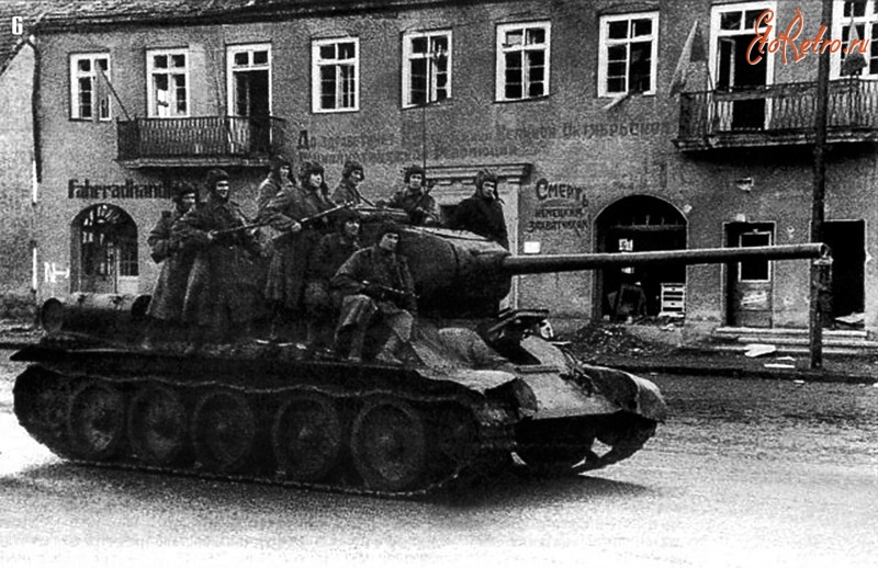 Калининградская область - Танк Т-34-85 с десантом автоматчиков проходит по улице одного из городов Восточной Пруссии
