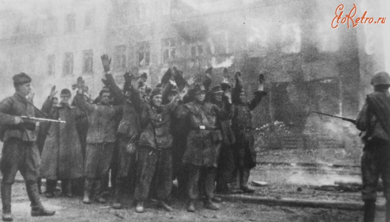 Калининград - Красноармейцы охраняют пленных немецких солдат у горящего здания во взятом Кенигсберге.