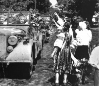 Украина - Украинские девушки в национальных костюмах бросают цветы проезжающей немецкой колонне.